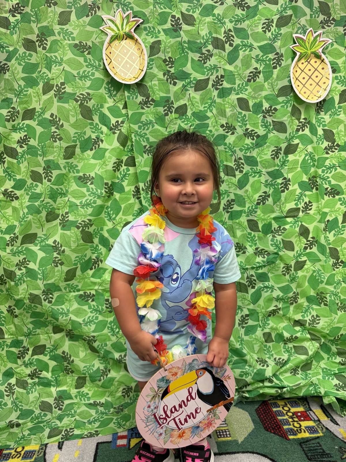 A smiling preschooler in a flower lei at an island themed party