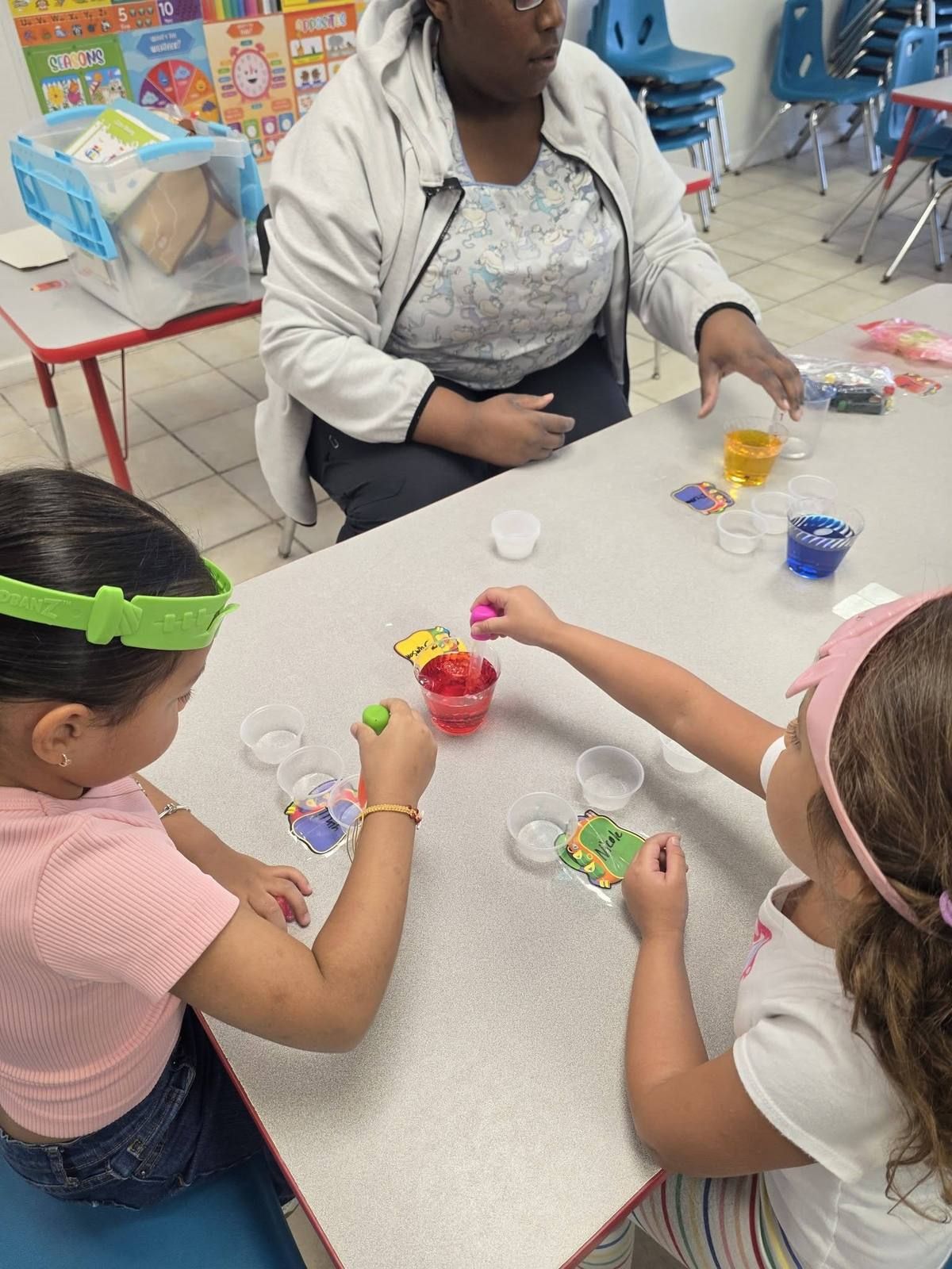 Kids mixing colored water in cups at the science table