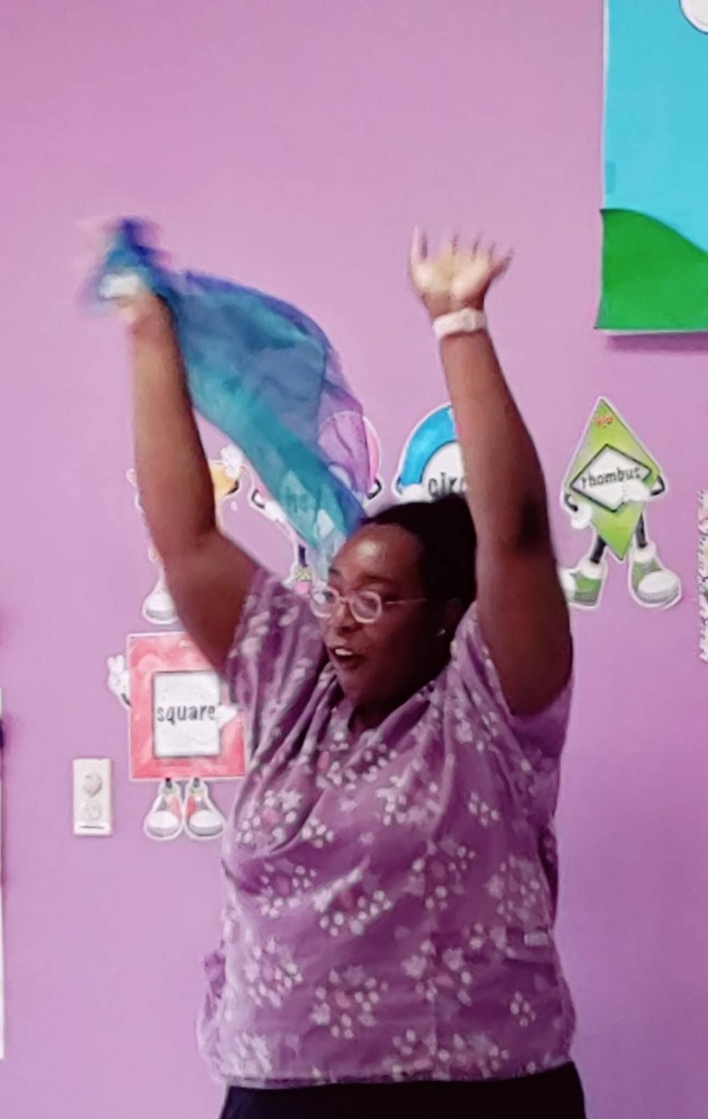 A teacher cheering with a scarf during music and movement