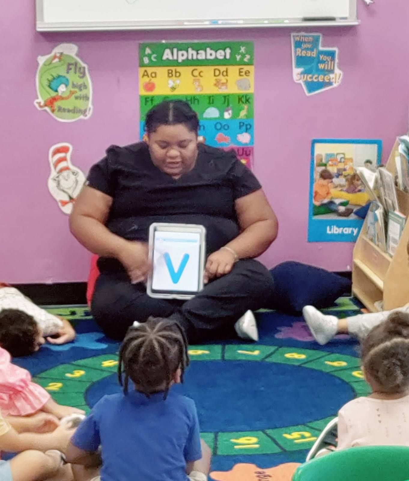 A teacher showing a letter card to the class at circle time