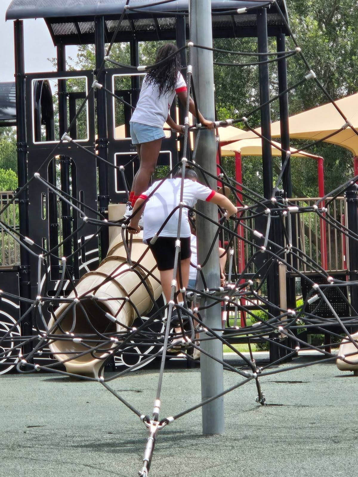 Kids climbing a rope structure at the playground