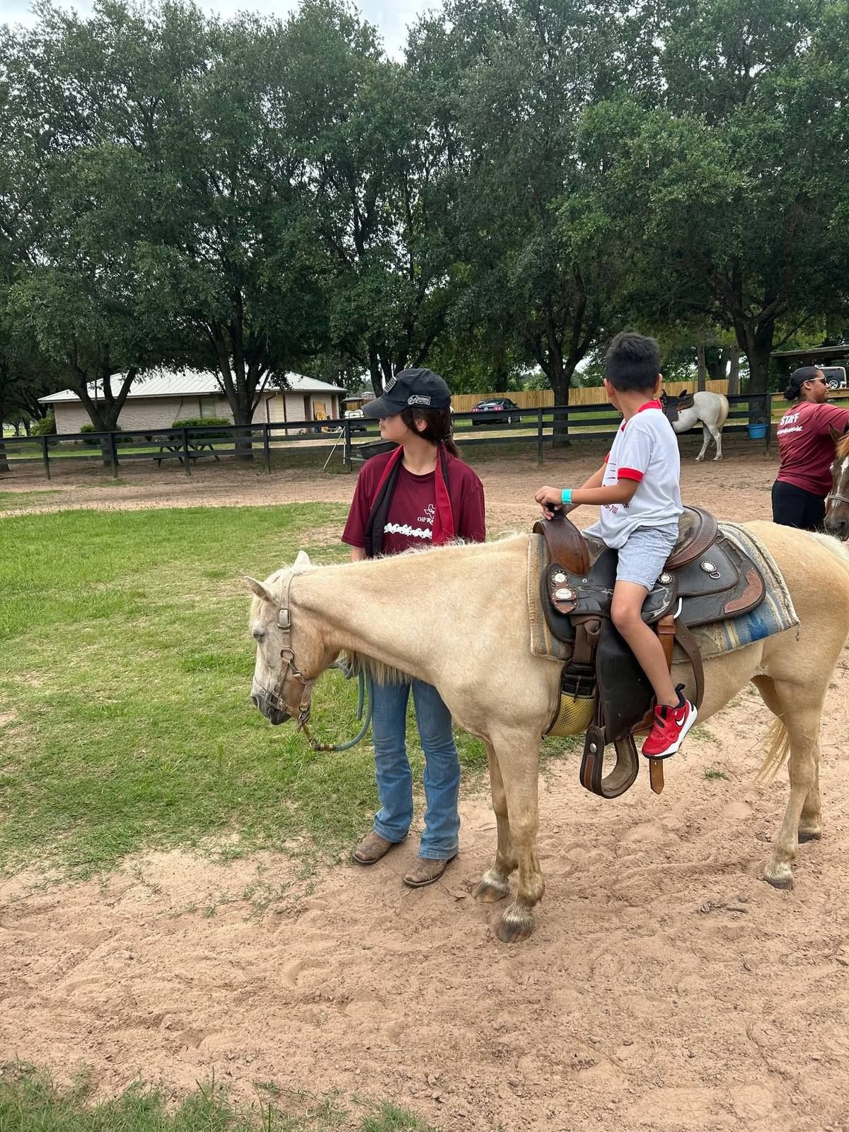 A child on horseback at the ranch with a guide