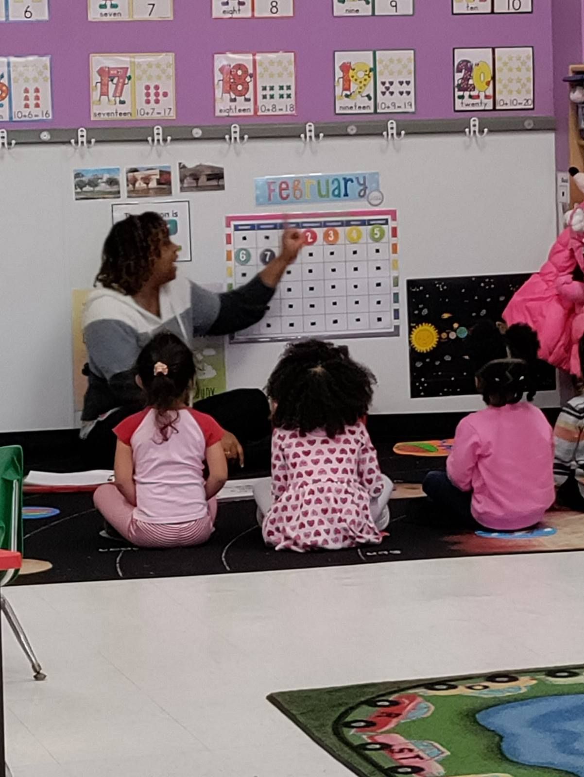 A teacher going over the calendar with preschoolers