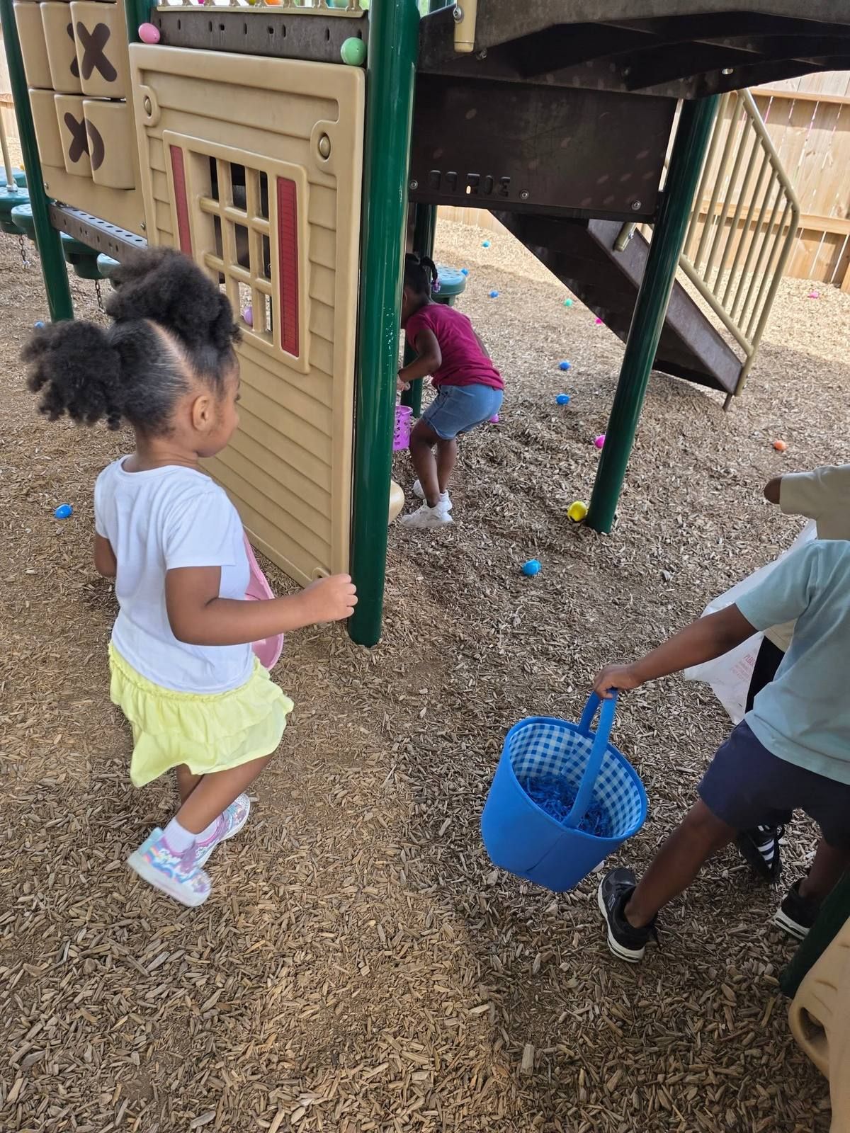 Kids hunting for eggs around the playhouse