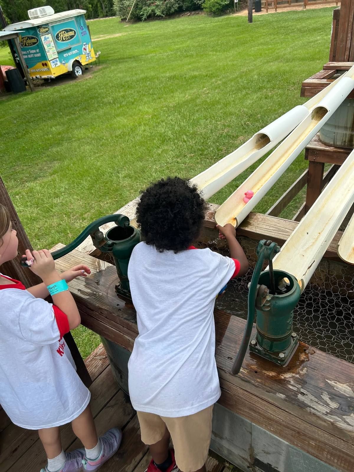 Kids pumping water at a farm water play station