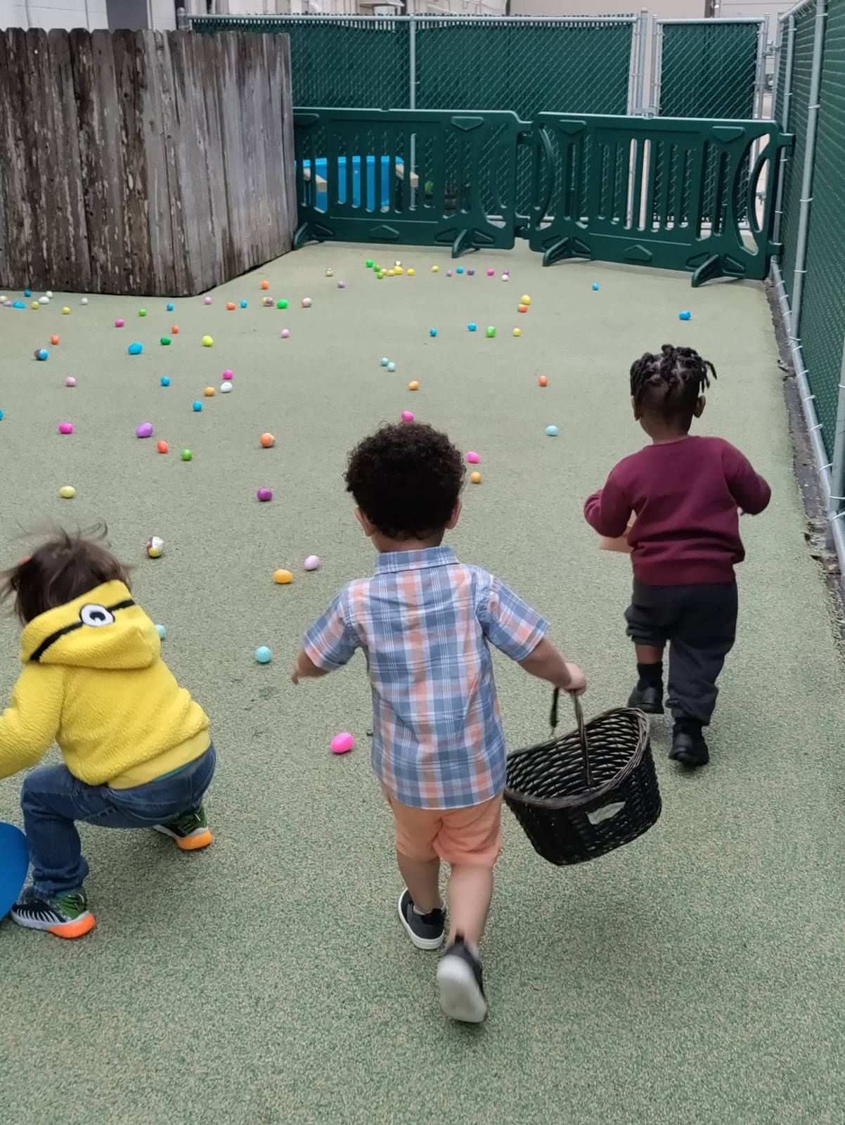 Toddlers running to collect eggs on the playground