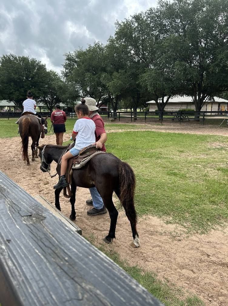 Kids riding horses on a field trip