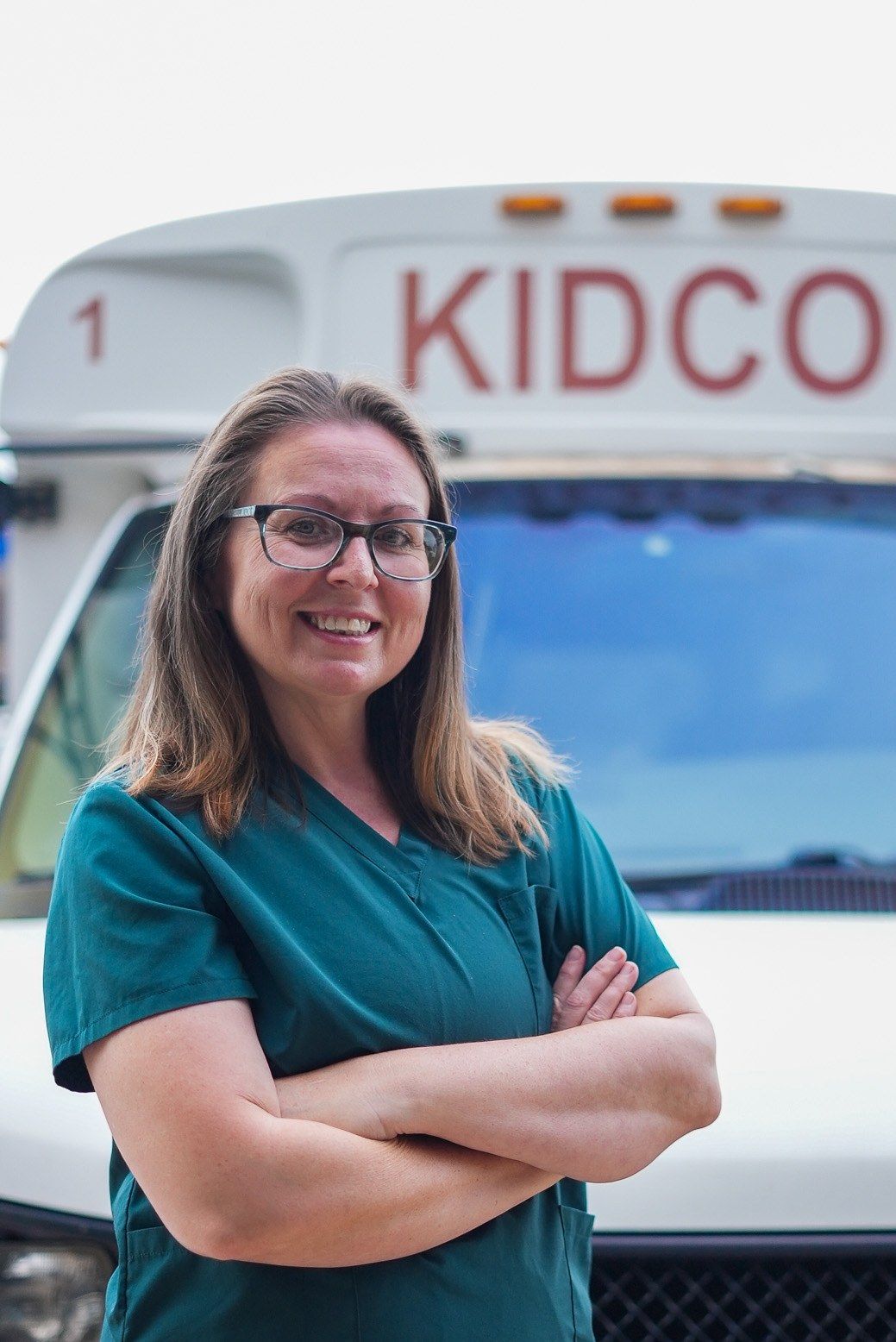 Monica Sanchez, Mrs. Monica, Kidco's director, in front of the Kidco bus